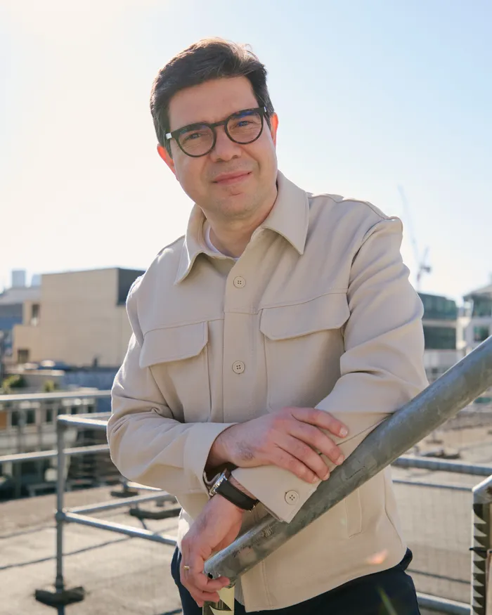 Bruno Genovese on a London rooftop, leaning on a railing
